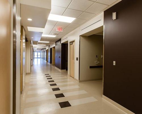 加州质子癌治疗中心走廊的内部照片. 棕色和白色的墙壁排列在走廊上.