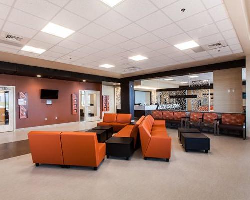 TMC林孔健康园区内的等候区. 房间中央放着橙色的椅子和棕色的桌子.